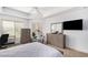 Comfortable bedroom with neutral walls and carpet, furnished with a bed, dressers, and a wall-mounted TV at 14000 N 94Th N St # 1129, Scottsdale, AZ 85260