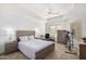 Bright bedroom with a queen bed, desk, ceiling fan, and exercise bike at 14000 N 94Th N St # 1129, Scottsdale, AZ 85260