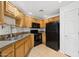 Kitchen with wooden cabinetry, black appliances, and tile flooring offering a functional cooking space at 14000 N 94Th St # 3198, Scottsdale, AZ 85260