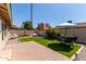 This backyard offers great entertaining space, with artificial grass, a seating area, and a dining area with umbrella at 14235 N 26Th Ln, Phoenix, AZ 85023