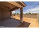 This covered back patio features a ceiling fan and is enclosed with a concrete block wall at 15634 W Georgia Dr, Surprise, AZ 85379