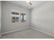 A simple bedroom has neutral carpet, baseboards, ceiling fan, and a double window at 15634 W Georgia Dr, Surprise, AZ 85379