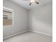 A simple bedroom has neutral carpet, baseboards, ceiling fan, and a window at 15634 W Georgia Dr, Surprise, AZ 85379