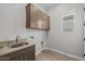 A spacious laundry room features upper cabinets, sink, and new vinyl flooring at 15634 W Georgia Dr, Surprise, AZ 85379