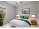 Stylishly staged bedroom with modern decor, neutral carpet, ceiling fan, and natural light at 15634 W Georgia Dr, Surprise, AZ 85379