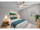 Stylishly staged bedroom with modern decor, neutral carpet, ceiling fan, and natural light at 15634 W Georgia Dr, Surprise, AZ 85379