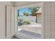 A view of the backyard through a window shows desert landscaping with rocks and plants and a block fence at 1606 N Apache Dr, Chandler, AZ 85244