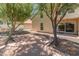 Backyard with a brick patio area, desert landscaping, and mature trees, perfect for relaxing or entertaining at 1606 N Apache Dr, Chandler, AZ 85244