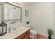Cozy bathroom featuring a wood framed mirror, wood vanity, and a white toilet at 1606 N Apache Dr, Chandler, AZ 85244