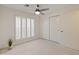 Bright bedroom featuring neutral carpeting, plantation shutters, closet and ceiling fan at 1606 N Apache Dr, Chandler, AZ 85244