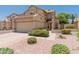 Charming two-story home featuring a two-car garage and beautifully landscaped front yard with desert rock and green bushes at 1606 N Apache Dr, Chandler, AZ 85244