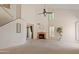 Bright living room features a vaulted ceiling, fireplace, ceiling fan, plantation shutters, and neutral carpeting at 1606 N Apache Dr, Chandler, AZ 85244