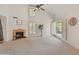 Spacious living room with tall ceilings, a fireplace, a ceiling fan, plantation shutters, and neutral color palette at 1606 N Apache Dr, Chandler, AZ 85244