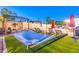 Relaxing backyard with a hammock, artificial turf, patio chairs and a view of the sparkling pool beyond at 16602 N 66Th St, Scottsdale, AZ 85254