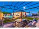 Inviting backyard featuring a sparkling pool, lounge chairs, and a covered patio with comfortable seating under the moonlit sky at 16602 N 66Th St, Scottsdale, AZ 85254