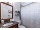 Bathroom featuring granite countertops, framed mirror, patterned shower curtain, and soft lighting at 16602 N 66Th St, Scottsdale, AZ 85254