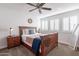 Bright bedroom with a wooden bed frame, ceiling fan, and white plantation shutters at 16602 N 66Th St, Scottsdale, AZ 85254
