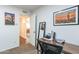 Office with desk, chair, and artwork, leading to a hallway with pool table in the background at 16602 N 66Th St, Scottsdale, AZ 85254