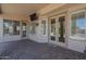 Back patio with french doors leading to interior; features a mounted TV and brick floor at 1826 W Oriole Way, Chandler, AZ 85286