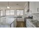Open concept kitchen with island, marble countertops, stainless appliances, and neutral backsplash at 1826 W Oriole Way, Chandler, AZ 85286