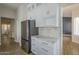 Kitchen features stainless steel refrigerator, white cabinets, mosaic backsplash, and marble countertops at 1826 W Oriole Way, Chandler, AZ 85286