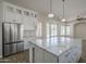 Spacious kitchen with a large island, white cabinets, marble countertops, and stainless steel refrigerator at 1826 W Oriole Way, Chandler, AZ 85286