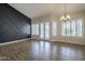 Spacious living room boasts wood-look floors, modern lighting, French doors, and a stylish accent wall at 1826 W Oriole Way, Chandler, AZ 85286