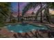 Backyard pool and fence surrounded by palm trees at dusk at 1826 W Oriole Way, Chandler, AZ 85286