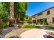 Landscaped backyard with a custom pool, mature trees, and rock features that create a private oasis at 18402 E Oak Hill Ln, Queen Creek, AZ 85142