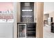 A bar featuring a beverage refrigerator, wine rack, shelves, and tiled countertop in the laundry room area at 18402 E Oak Hill Ln, Queen Creek, AZ 85142