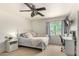 Bedroom with ceiling fan, desk, nightstand, and a bed with a patterned blanket at 18402 E Oak Hill Ln, Queen Creek, AZ 85142