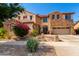 Charming two-story home featuring stone accents, a red tile roof, and a well-manicured front yard at 18402 E Oak Hill Ln, Queen Creek, AZ 85142