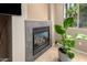 Modern fireplace with tile surround and a decorative green houseplant at 18402 E Oak Hill Ln, Queen Creek, AZ 85142