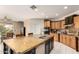 Spacious kitchen featuring a large island with seating, modern appliances, and oak cabinets at 18402 E Oak Hill Ln, Queen Creek, AZ 85142