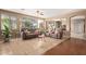 The living room has plush sofas, a ceiling fan, large windows and a mix of hardwood and tile flooring at 18402 E Oak Hill Ln, Queen Creek, AZ 85142