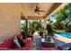 Relaxing covered patio with comfortable seating and a ceiling fan overlooking a lush backyard at 18402 E Oak Hill Ln, Queen Creek, AZ 85142