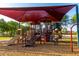 Community playground with multiple play structures, slides, climbing areas, and a protective shade canopy at 18402 E Oak Hill Ln, Queen Creek, AZ 85142