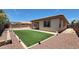 Backyard featuring artificial grass, stone landscaping, and a patio cover at 18617 W Williams St, Goodyear, AZ 85338