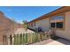 A fenced backyard featuring an artificial turf lawn, gravel landscaping, and young shade trees at 18617 W Williams St, Goodyear, AZ 85338