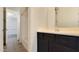 Bathroom featuring dark cabinets, tile floors, and a view into the adjacent room with tub and toilet at 18617 W Williams St, Goodyear, AZ 85338