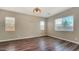 Light-filled bedroom featuring laminate flooring and multiple windows at 18617 W Williams St, Goodyear, AZ 85338
