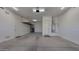 A spacious garage with clean concrete floors, overhead storage, and a hot water tank at 18617 W Williams St, Goodyear, AZ 85338