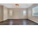 Open room with wood floors, neutral paint, and modern light fixture at 18617 W Williams St, Goodyear, AZ 85338