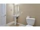 Well-lit powder room features a pedestal sink, oval mirror and a white toilet for guest convenience at 18617 W Williams St, Goodyear, AZ 85338
