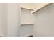 Spacious walk-in closet features built-in wooden rods and white shelving for organized storage at 18617 W Williams St, Goodyear, AZ 85338