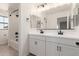 Modern bathroom featuring double sinks, white cabinets, black hardware and a combined shower and tub at 18778 E Panchito Dr, Gold Canyon, AZ 85118
