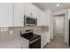 Close-up of the kitchen featuring a stainless steel microwave, oven, white cabinets, and light gray backsplash at 18778 E Panchito Dr, Gold Canyon, AZ 85118