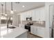 Modern kitchen features white cabinets, stainless steel appliances, stylish backsplash, and an island sink with pendant lighting at 18778 E Panchito Dr, Gold Canyon, AZ 85118