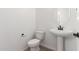 Bright powder room featuring modern fixtures, pedestal sink, and a sleek oval mirror at 18778 E Panchito Dr, Gold Canyon, AZ 85118