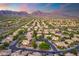 Expansive aerial view showcasing a desert community nestled against a picturesque mountain range at sunset at 19275 N 88Th Way, Scottsdale, AZ 85255